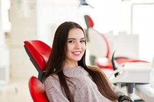 Smiling young woman in dental chair