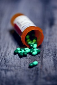 Pill bottle spilled over revealing green medicine