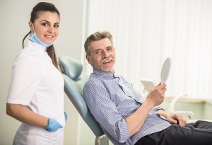 Patient in dental chair next to hygienist