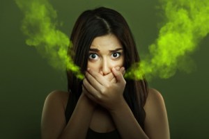 Woman covering her mouth with hands due to bad breath